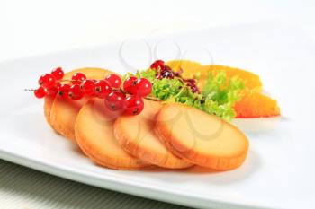 Slices of smoked cheese garnished with fruit