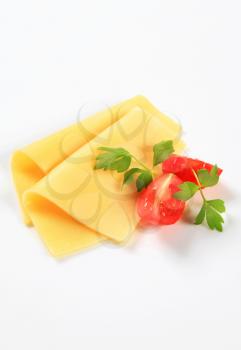 Thin slices of yellow cheese and tomato wedges
 Thin slices of yellow cheese and tomato wedges