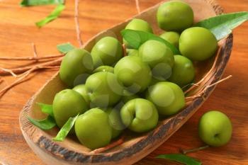 Fresh green olives in natural wood bowl