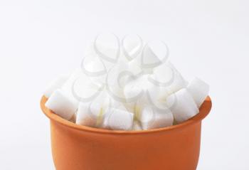 White sugar cubes in terracotta dish