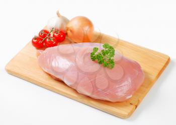 Raw turkey breast and vegetables on cutting board