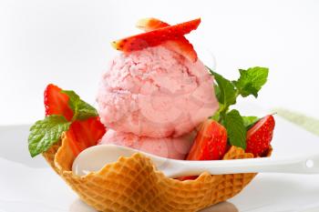 Scoops of strawberry ice cream in waffle basket