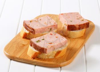 Slices of spicy meat loaf on crispy bread roll