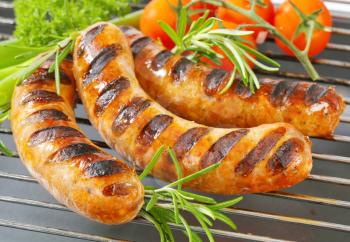 Grilled bratwursts on barbecue grid