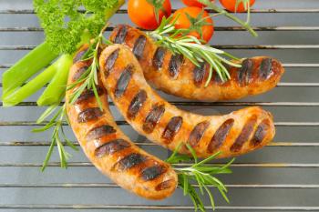 Grilled bratwursts on barbecue grid