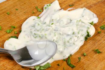 Sour cream and chopped parsley on cutting board