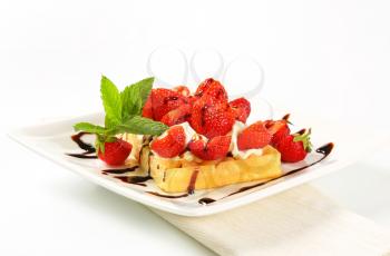 Belgian waffle with whipped cream and fresh strawberries