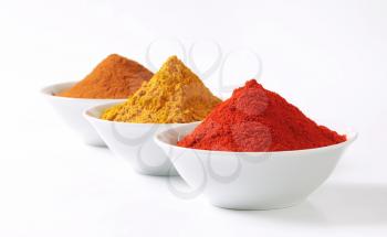 Bowls of curry powder, paprika and ground cinnamon