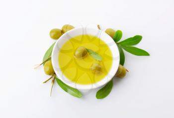 Pitted green olives and bowl of oil