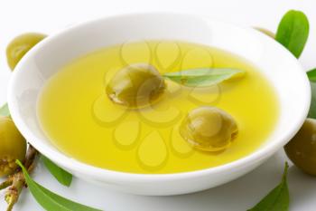 Pitted green olives and bowl of oil