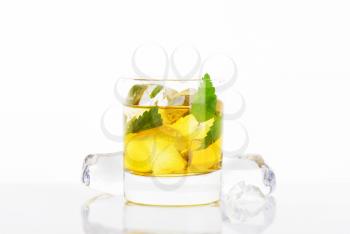 glass of apple juice with mint and ice on white background
