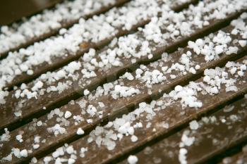 Detail of hailstones on wooden bench