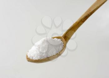Coarse grained salt on wooden spoon