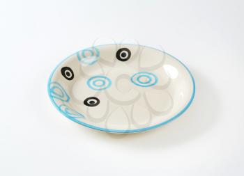 White soup plate with black and blue circles