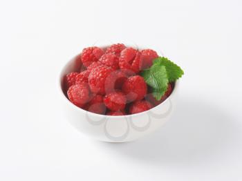 bowl of fresh raspberries on white background