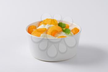 bowl of sour cream with peeled tangerine segments