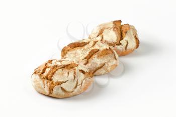 three freshly baked loaves of bread with crunchy crust
