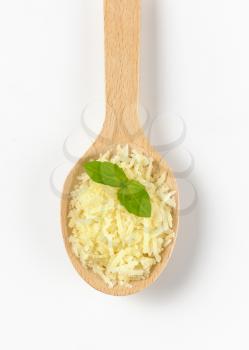 spoon of shredded parmesan cheese with basil