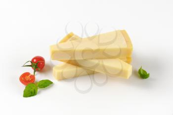 three wedges of fresh parmesan cheese on white background