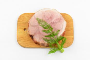 stack of ham slices and dill on wooden cutting board