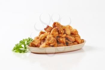 plate of salty pork greaves on white background