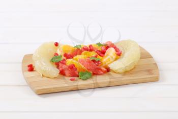 Citrus fruit salad with pomegranate seeds on cutting board