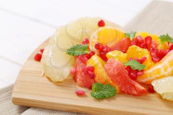 Citrus fruit salad with pomegranate seeds on cutting board