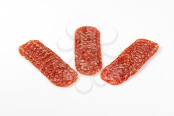 thin slices of salami arranged on white background