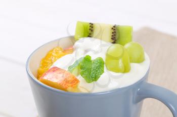 cup of fresh fruit salad with white yogurt - close up