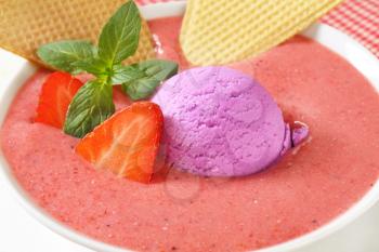 Chilled strawberry soup with scoop of ice cream and wafers