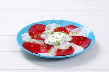 plate of thin beetroot and white radish slices with yogurt