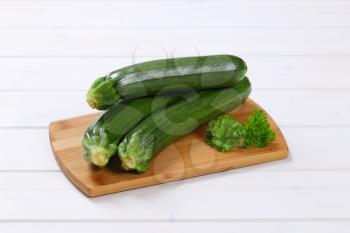 fresh green zucchini on wooden cutting board