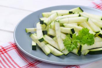 plate of zucchini strips on checkered dishtowel - close up