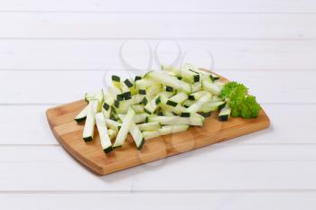 pile of zucchini strips on wooden cutting board