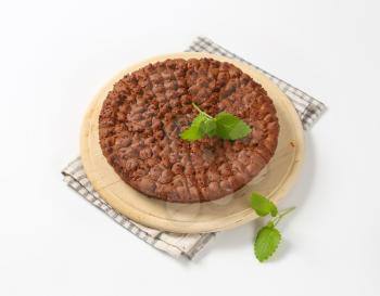 homemade chocolate round cake on wooden cutting board
