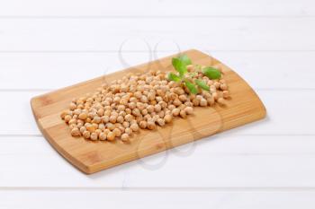pile of raw chickpeas on wooden cutting board