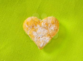 heart shaped cookie on green background