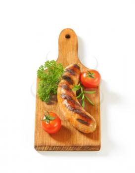 Grilled bratwurst on cutting board