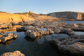 Maltese coastline with cliffs and old watch tower