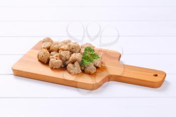 pile of soy meat cubes on wooden cutting board