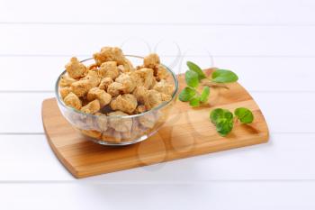 bowl of soy meat cubes on wooden cutting board