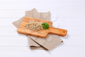 pile of cooked pearl barley on wooden cutting board