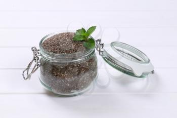 jar of chia seeds on white wooden background