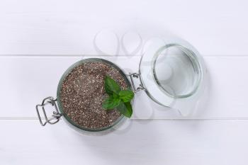 jar of chia seeds on white wooden background