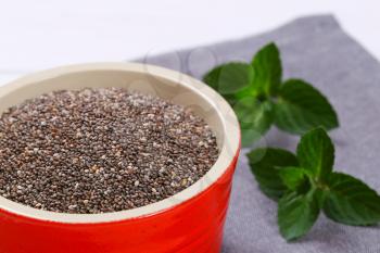 bowl of chia seeds on grey place mat -  close up