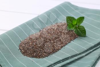 pile of chia seeds on grey place mat - close up