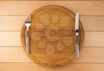 kitchen utensils at cutting board on wooden background
