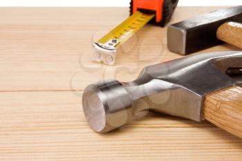 hammer and tape measure on wood brick