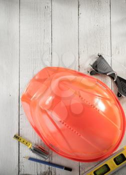 hardhat and safety glasses on wooden background