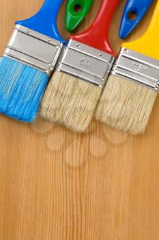 colorful paintbrush on wood background texture